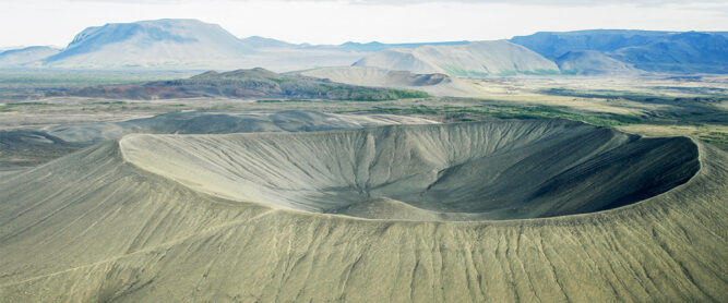 Großer Krater in trockener, grünlicher Landschaft, Island, Vulkan.