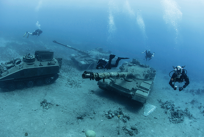 Taucher und versunkene Kampfpanzer unter Wasser im Roten Meer