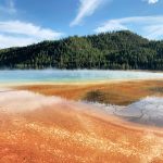 Rot-blauer See mit Wald im Yellowstone Nationalpark. © Jyoti Mann