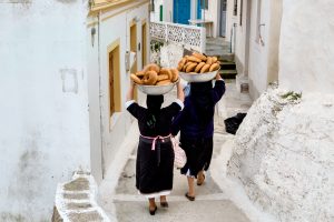 Frauen tragen das Ostergebäck, Tsoureki, auf dem Kopf durch das Dorf, Griechenland