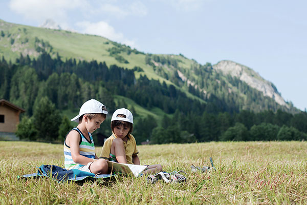 kinder-lesen-wiese-schweizer-alpen