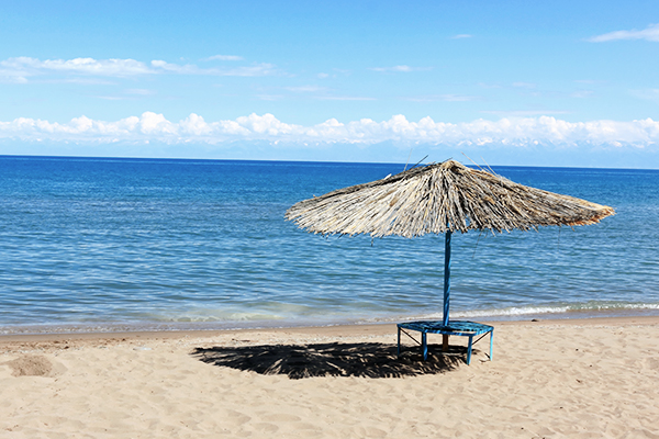 Ein Sonnenschirm am Strand bei Issyk-Kul