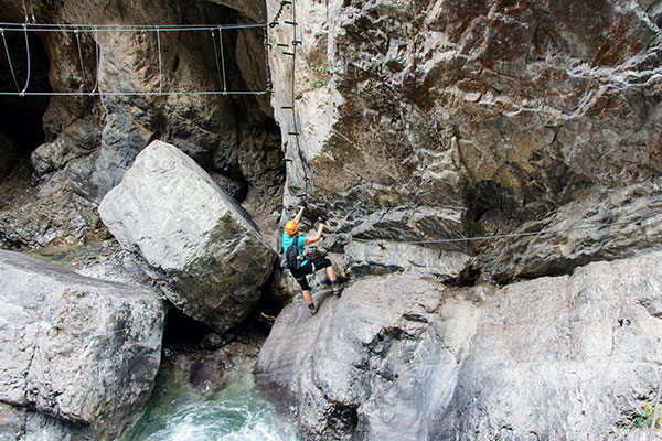 Kletterer hängt an Felsen über Bach in Pirknerklamm, Österreich