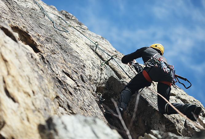 Kletterer erklimmt einen Felsen auf dem Klettersteig