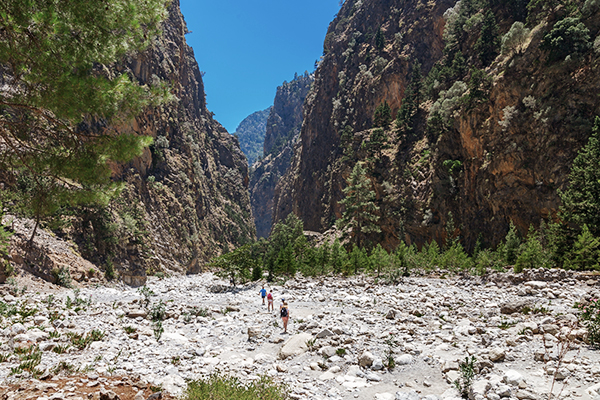 Drei Wandernde zwischen den Felsen der Samaria Schlucht auf Kreta