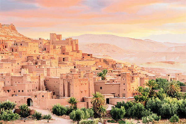 Blick auf das Ksar Ait Ben Haddou in Marokko mit Palmen im Vodergrund