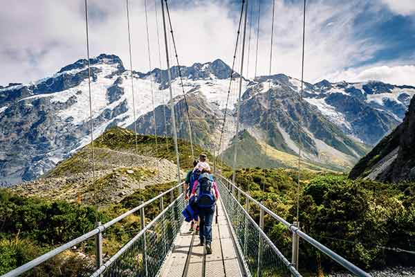 Eine Familie wandert über eine Hängebrücke in Mount Cook