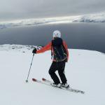 Skitourengeher blickt in die Ferne, wolkenbehangener Himmel
