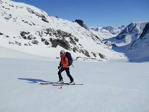 Skitourengeher auf glatter, verschneiter Strecke, klarerHimmel