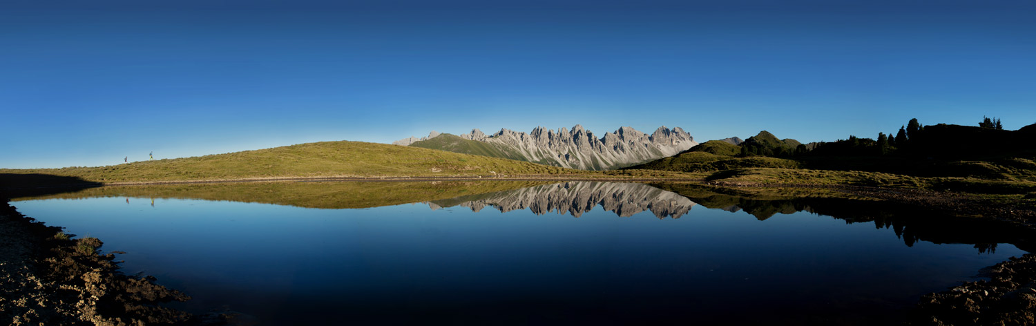 see, in dem sich berge am horizont spiegeln