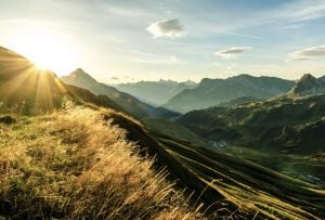 Sonnenaufgang in geschichteter Bergsilhoutten an einem Sommertag.