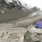 Geröllfläche, ein blaues Schild mit roter Schrift "1990" auf der rechten Seite