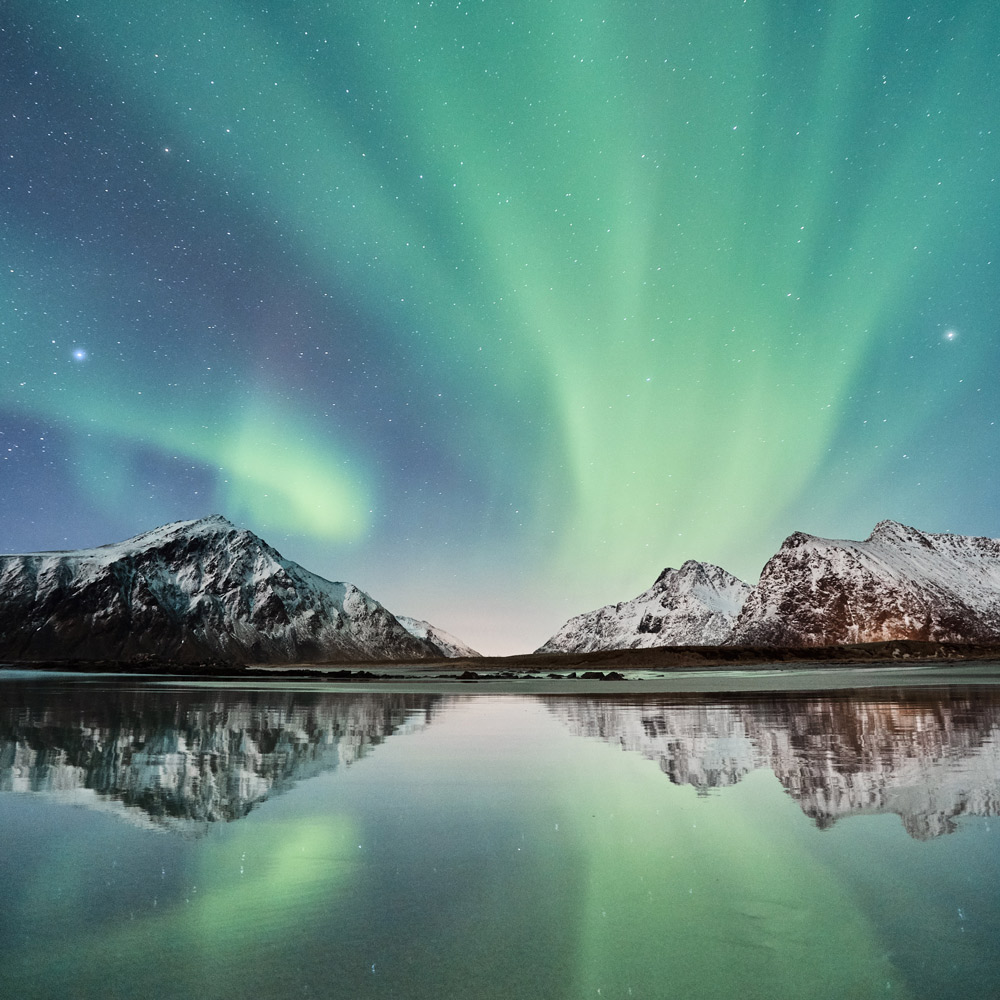 See und Berge und nächtlicher Himmel mit grünem Licht