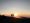 Sonnenuntergang auf einem Berg, roter Himmel und schwarze Umrisse, Silhouetten zweier Wanderer