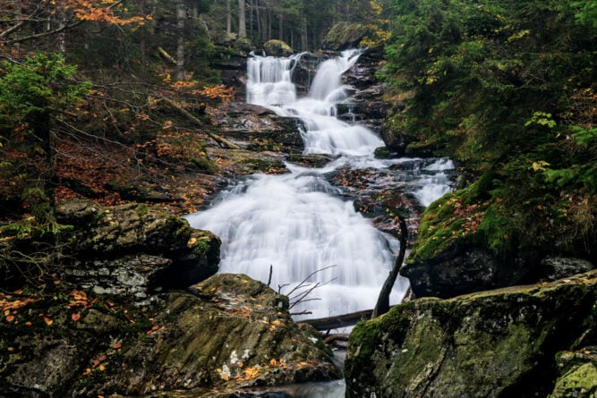 Kristallklare kleine Wasserfälle durch den herbstlichen Wald, Deutschland