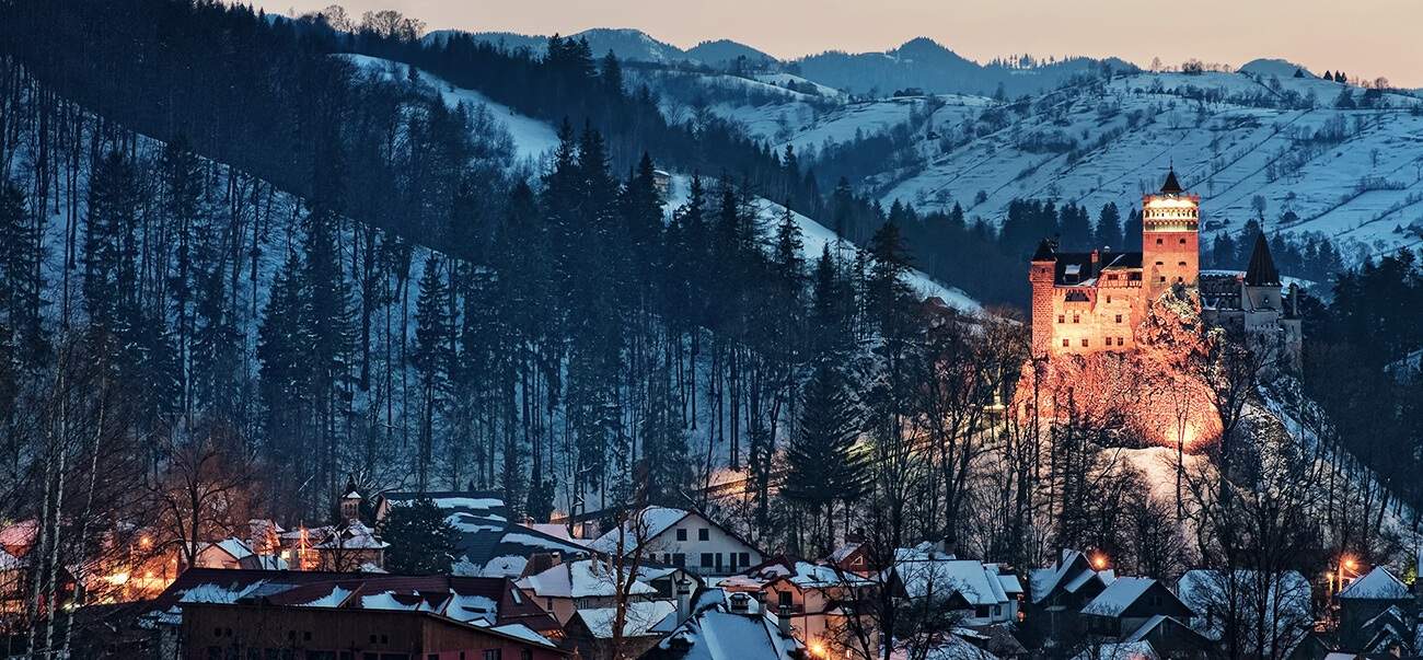erleuchtetes Schloss Bran in Winterlandschaft