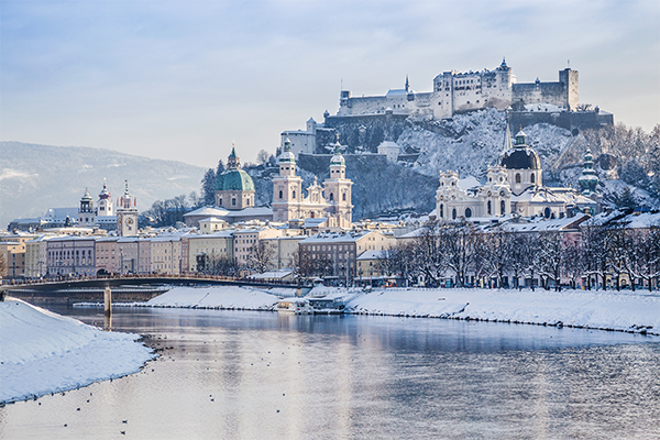 Aussicht auf das schneebedeckte Salzburg mit der Salzach im Vordergrund