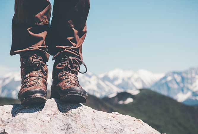 Wanderer auf Stein mit Schuhen