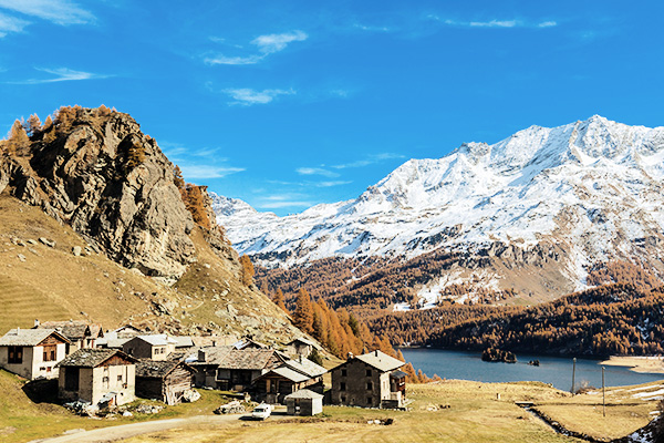 Grevasalvas vor dem Silersee und herbstliche Bäume im Hintergrund
