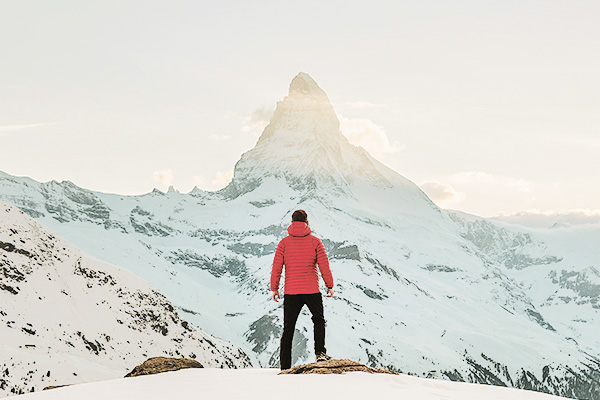 Wanderer von hinten im Winter mit Blick auf das Matterhorn
