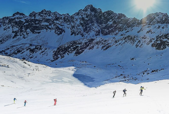 Skitourengeher hintereinander bei sonnigem Winterwetter uf der Hohen Tatra