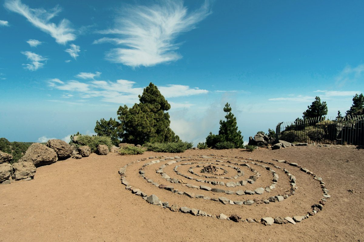 Spirale aus kleinen Steinen auf Sand