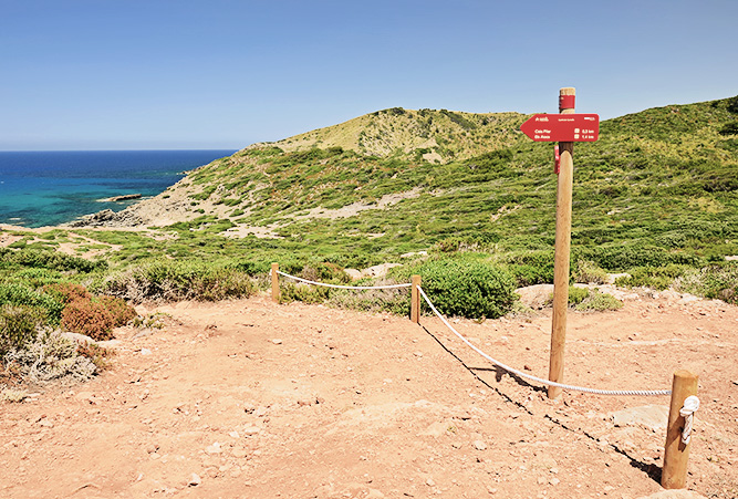 Wegweiser am Wanderweg an der Küste nahe der Cala Pilar auf Menorca, Spanien