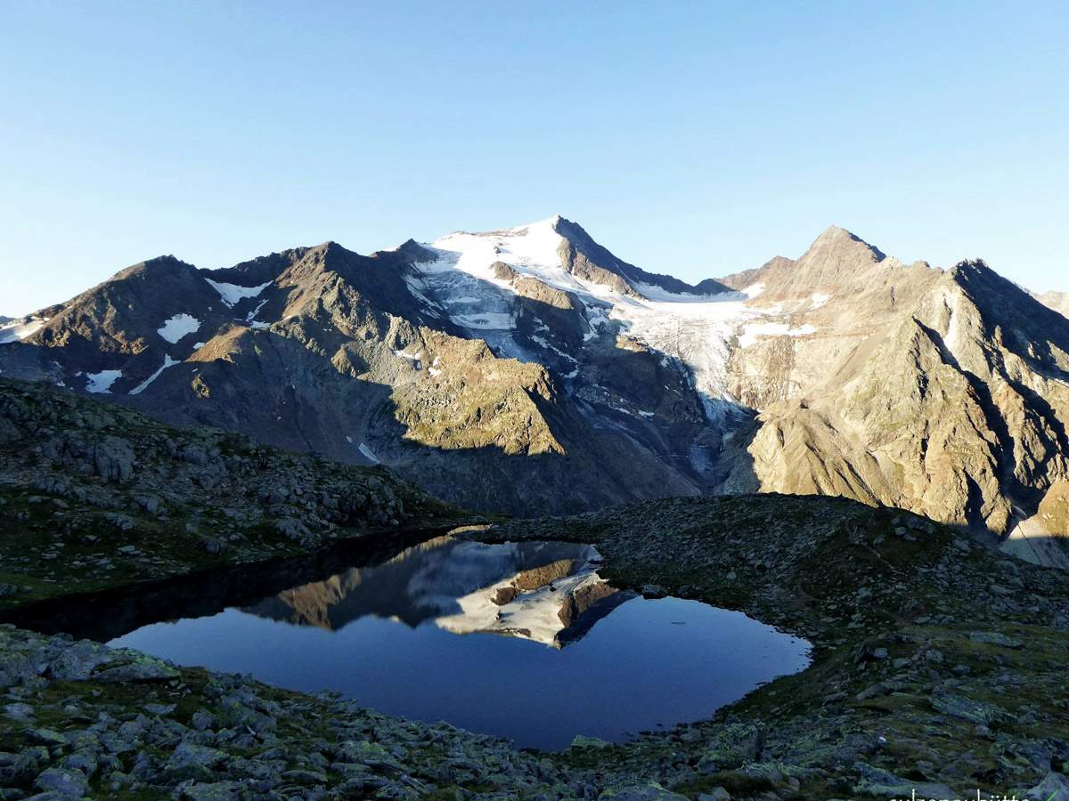 Ausblick auf Gletscher und Berge hinter Gebirgssee