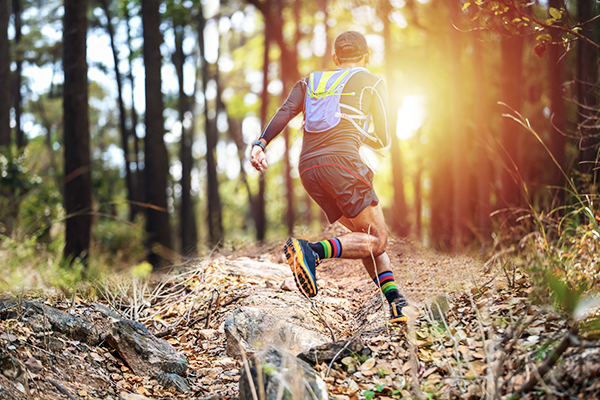 Trailrunner mit Laufrucksack im Wald