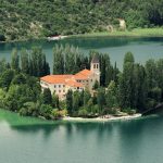 Kloster auf einer Insel in einem smaragdgrünen See