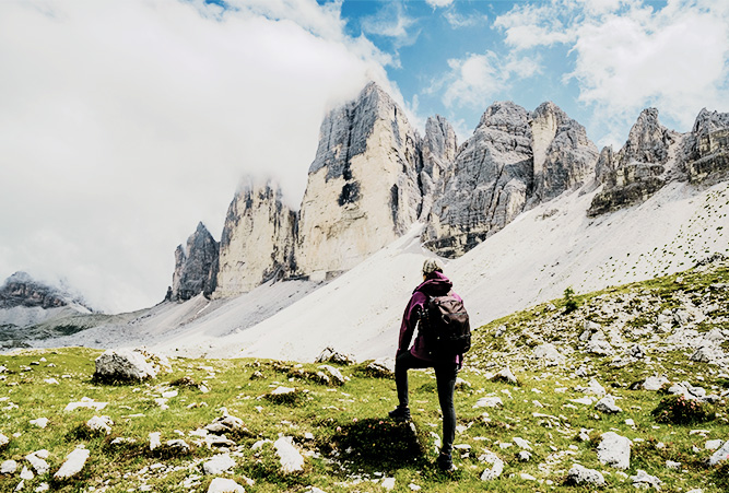 Wanderin blickt auf die drei Zinnen in den Wolken