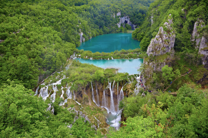 Türkises Wasser und kleine Wasserfälle in grünem Wald