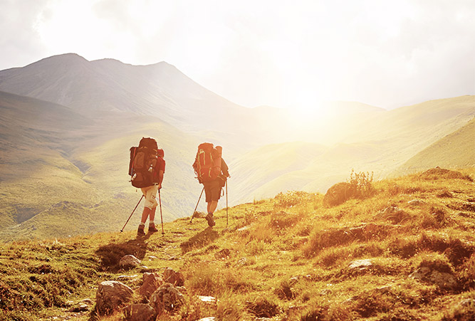 weitwandern zwei wanderer auf almwiese